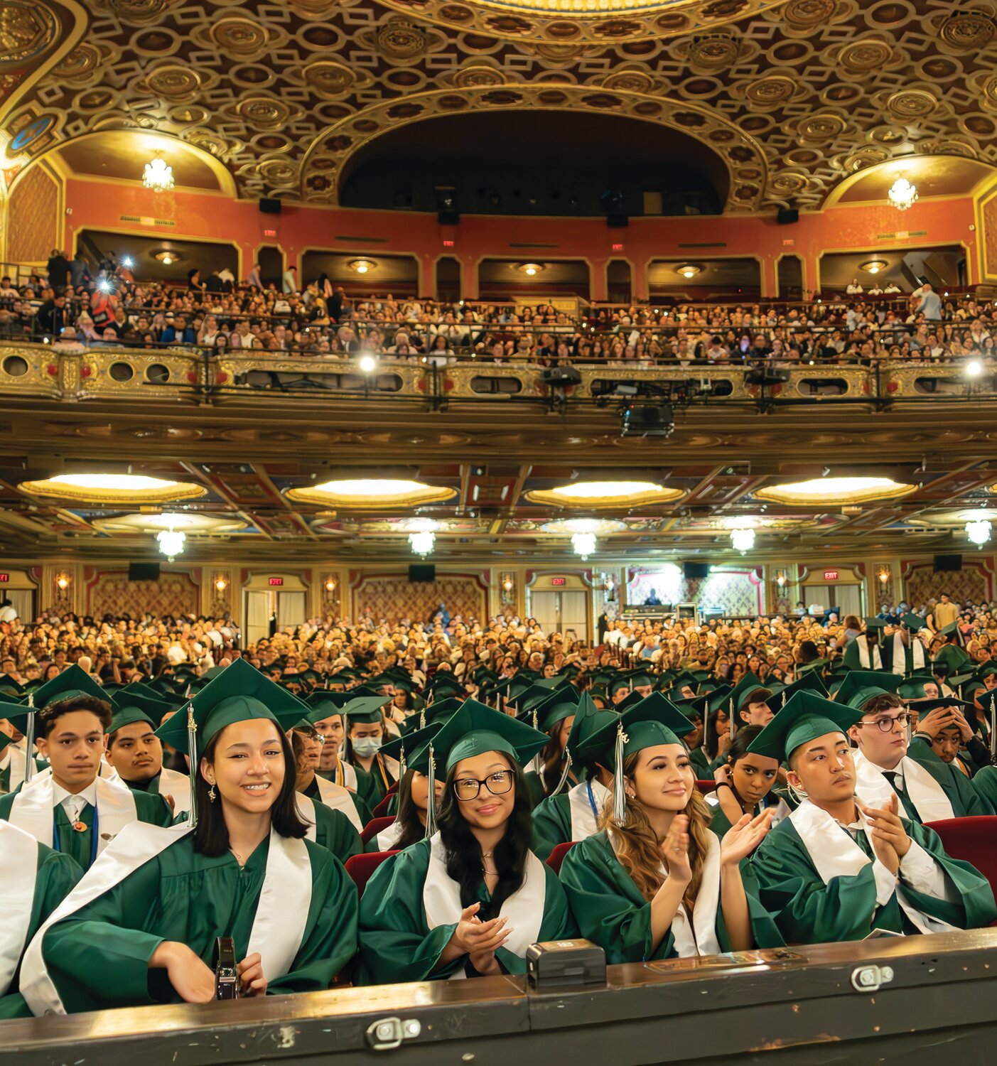 EXCITEMENT RISING: Soon to be graduates of Cranston High School East excitedly clap for the opening ceremonies that will end with them holding their diplomas. (Photo by Stephanie Bernaba)